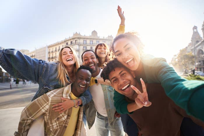 Group of joyful friends taking a selfie outdoors