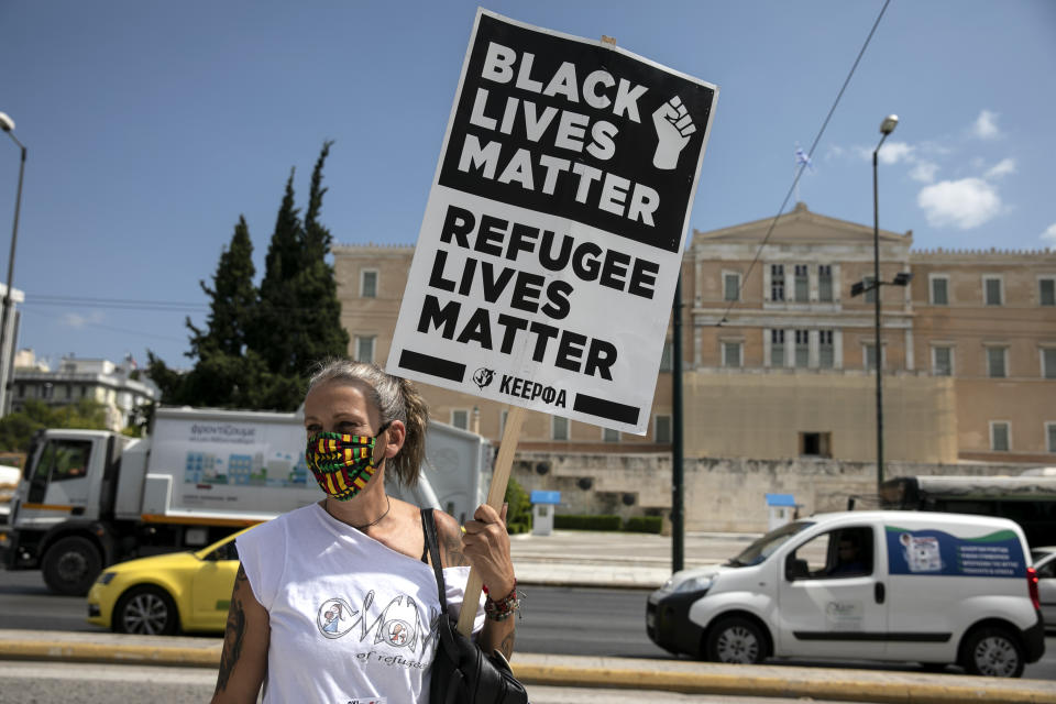 A protester raises a placard during a rally in support of the migrants on the island of Lesbos, in Athens, Saturday, Sep. 12, 2020. Thousands of asylum-seekers spent a fourth night sleeping in the open on the Greek island of Lesbos, after successive fires destroyed the notoriously overcrowded Moria camp during a coronavirus lockdown. (AP Photo/Yorgos Karahalis)