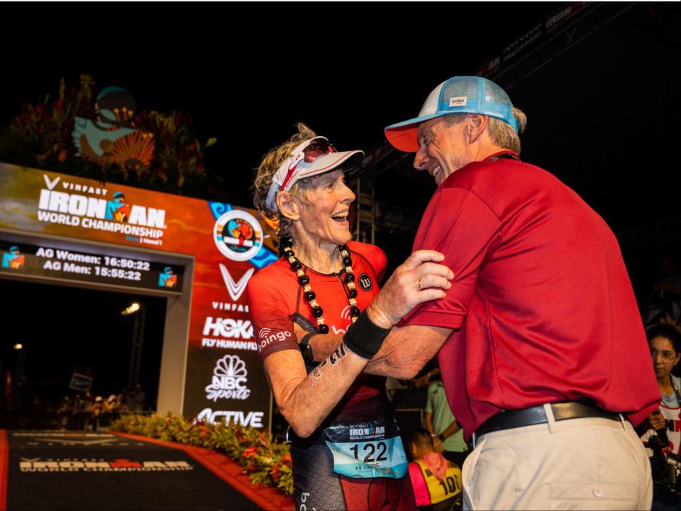 Cherie Gruenfeld and her husband embracing after she crosses the finish line at an Ironman Triathlon.