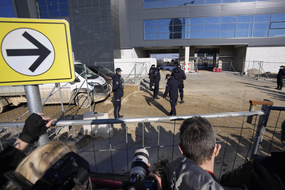 Police forces guard the area as journalist wait for arrival of Novak Djokovic in front of the VIP terminal at the Nikola Tesla airport in Belgrade, Serbia, Monday, Jan. 17, 2022. Djokovic is expected to arrive in the Serbian capital following his deportation from Australia on Sunday after losing a bid to stay in the country to defend his Australian Open title despite not being vaccinated against COVID-19. (AP Photo/Darko Vojinovic)