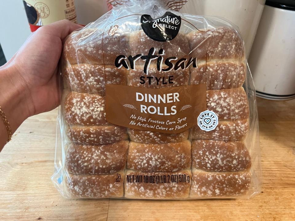 hand holding up a bag of signature select artisan dinner rolls