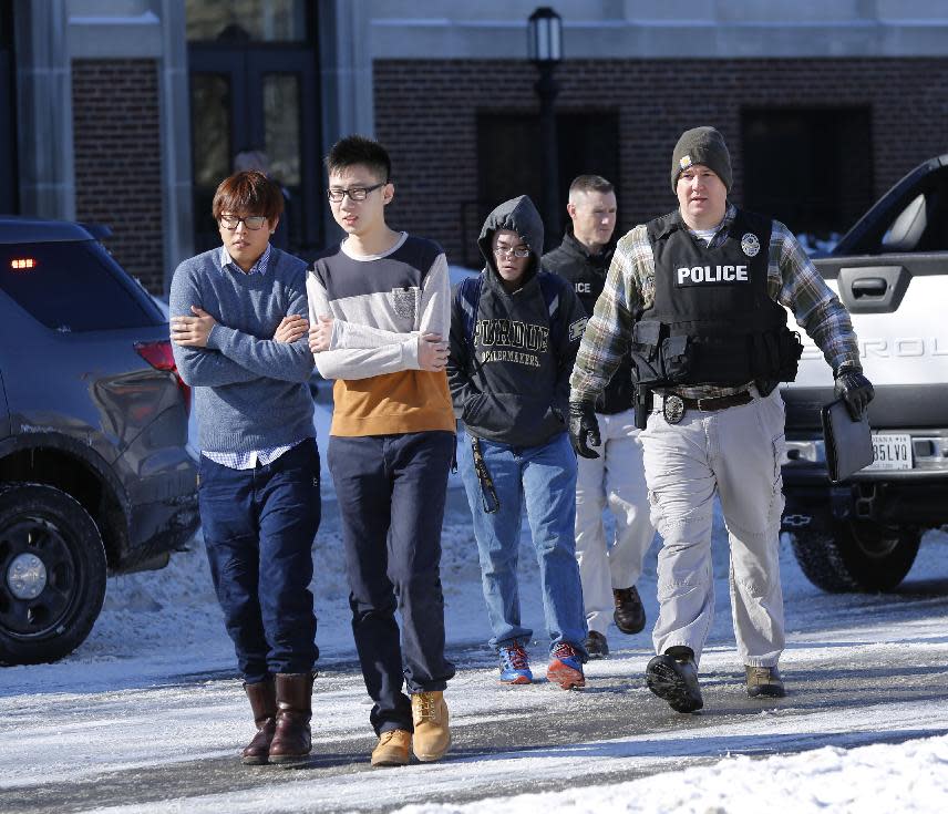 Police evacuate students from the Electrical Engineering building after shots were fired on Tuesday, Jan. 21, 2014, on the campus of Purdue University in West Lafayette, Ind. Officials at Purdue University say one person has been killed in a shooting at the campus classroom building. Purdue Provost Tim Sands says he didn't immediately know the identity of the person killed or the person's connection to the university. Campus police chief John Cox says the suspect is in custody after surrendering outside the Electrical Engineering Building following the shooting. (AP Photo/Journal & Courier, John Terhune) MANDATORY CREDIT