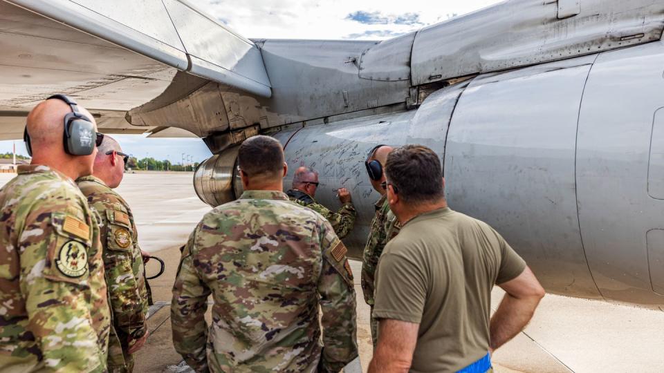 U.S. airmen with the 116th Air Control Wing, Georgia Air National Guard, sign an engine of an E-8C Joint STARS for its last mission at Ramstein Air Force Base,  Germany, Sept. 21. (Master Sgt. Jeff Rice/Air National Guard)