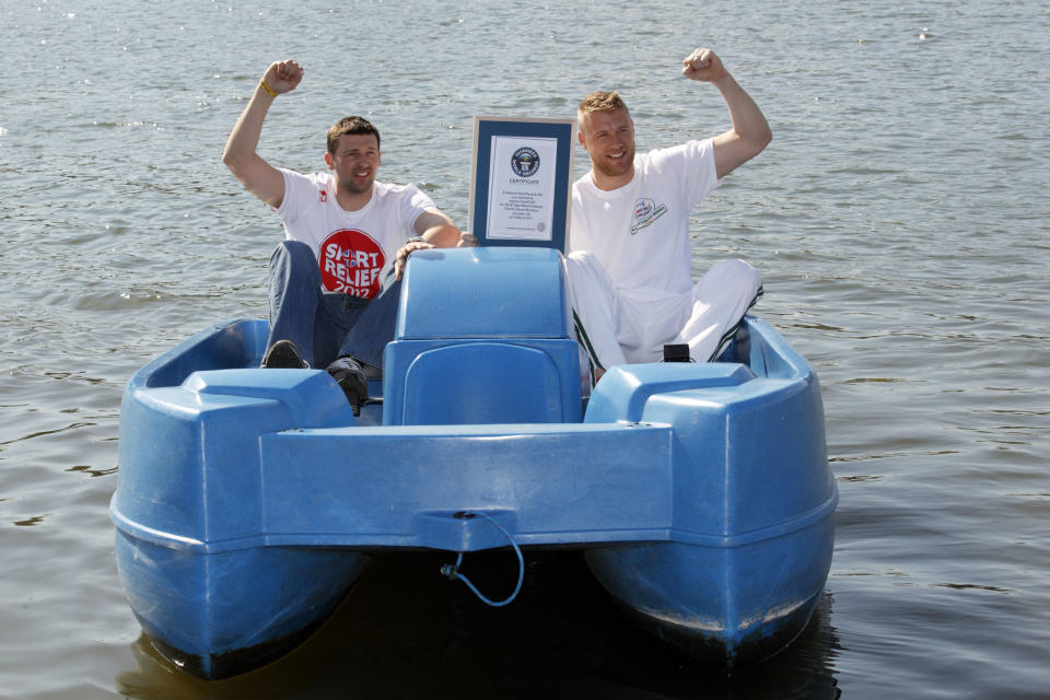 Former England cricketer Andrew "Freddie" Flintoff (R) and friend and England cricketer Steve Harmison (L) celebrate with their official certificate after a successful attempt to break the fastest 100m in a pedalo world record on Hyde Park boating lake in London on March 19, 2012. Flintoff attempted to set 12 Guinness World Records in 12 hours to raise money for the Sport Relief charity.  AFP PHOTO / JUSTIN TALLIS (Photo credit should read JUSTIN TALLIS/AFP/Getty Images)