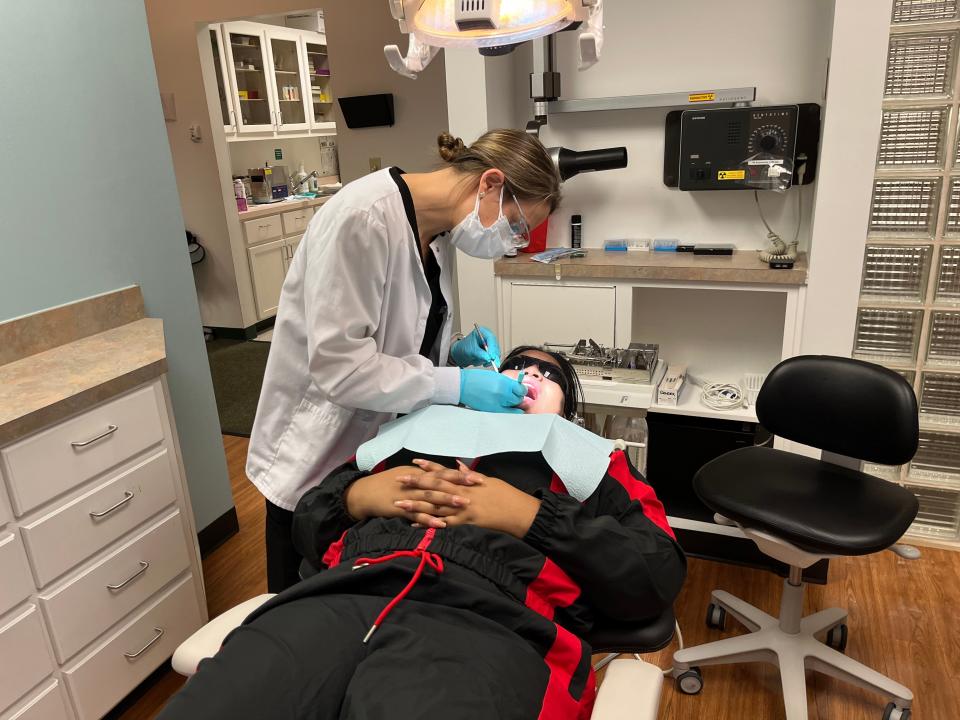Dr. Nichole Madison works on removing a tooth from Mia Yett. Madison said this tooth removal was an emergency and that nerves and bone could have been damaged.