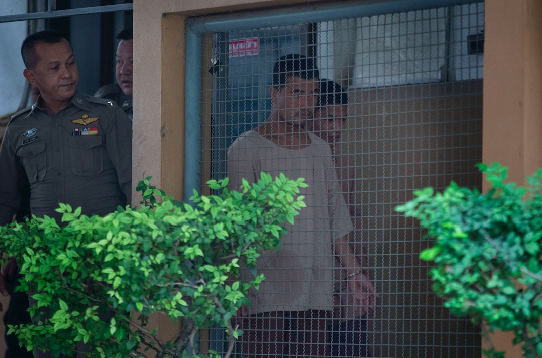 Wai Phyo, right, is escorted by police officers at the Supreme Court in Bangkok, Thailand (AP)