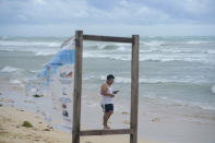 A man walks on the beach in the aftermath of Hurricane Beryl in Tulum, Mexico, Friday, July 5, 2024. (AP Photo/Fernando Llano)