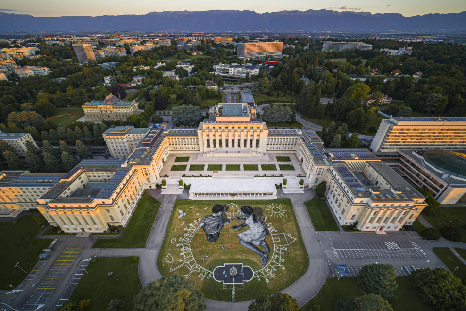 In this picture made available Friday, June 26, 2020 an aerial view shows a giant ephemeral landart painting by Swiss French artist Saype entitled "World in Progress" representing two children drawing their ideal world, at the European headquarters of the United Nations in Geneva, Switzerland, Wednesday, June 24, 2020. The artwork covering 6000 square meters was produced with biodegradable paints made from natural pigments such as coal and chalk. The fresco, offered by Switzerland, for the the 75th anniversary of the signing of the United Nations Charter in San Francisco on 26.6.1945 will be inaugurated by Swiss Federal Councillor Ignazio Cassis, in the presence of the Director-General of the United Nations Office in Geneva, Tatiana Valovaya. (Valentin Flauraud/Keystone via AP)