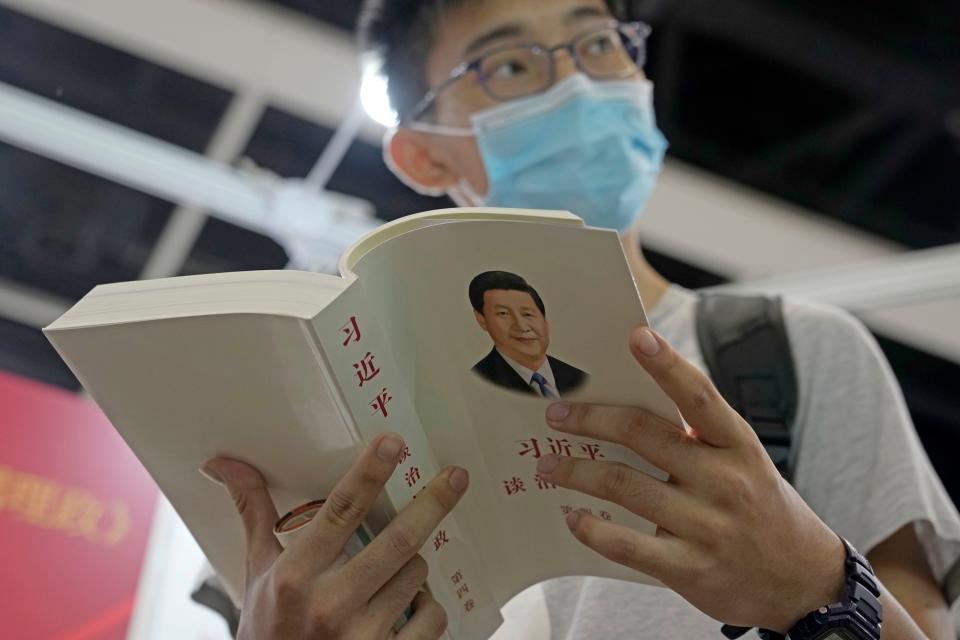 A man reads the books "Xi Jinping: The Governance of China" at a booth during the annual book fair in Hong Kong, Wednesday, July 20, 2022. The Hong Kong Book Fair will be held on July 20-26. (AP Photo/Kin Cheung) ORG XMIT: XKC115