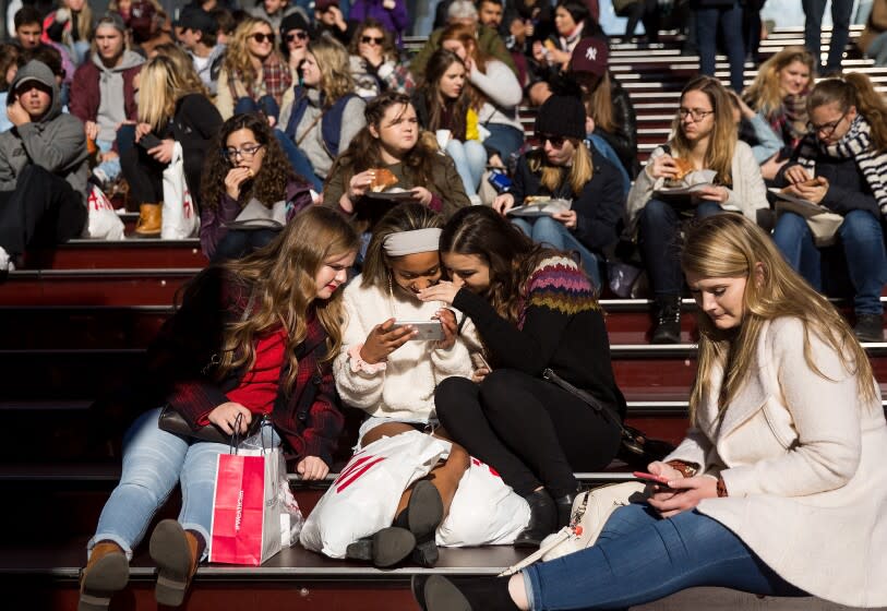 NEW YORK, NY - DECEMBER 01: A group of teens look at a photograph they took on a smartphone in Times Square, December 1, 2017 in New York City. The photo-sharing app Instagram has released data for its most-Instagrammed cities and locations for 2017. New York City is ranked number one, with Moscow and London coming in second and third. Among the most photographed locations in New York City were the Brooklyn Bridge, Times Square and Central Park. (Photo by Drew Angerer/Getty Images)