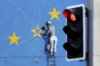 A view of the Banksy Brexit mural of a man chipping away at the EU flag in Dover, England, Tuesday, Dec. 11, 2018. Top European Union officials on Tuesday ruled out any renegotiation of the divorce agreement with Britain, as Prime Minister Theresa May fought to save her Brexit deal by lobbying leaders in Europe's capitals. (Gareth Fuller/PA via AP)