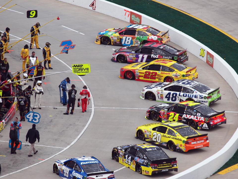 Cars sit on pit road before the start of a NASCAR Sprint Cup Series auto race at Martinsville Speedway, Sunday, March 30, 2014, in Martinsville, Va (AP Photo/Steve Shappard)