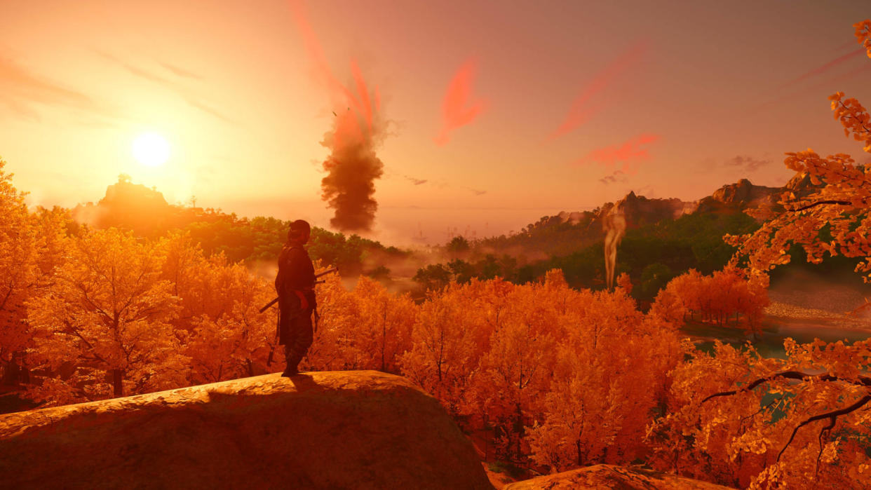  A screenshot from Ghost of Tsushima, showing a wide landscape, full of trees and hills, with the setting sun casting a red hue across the view. 