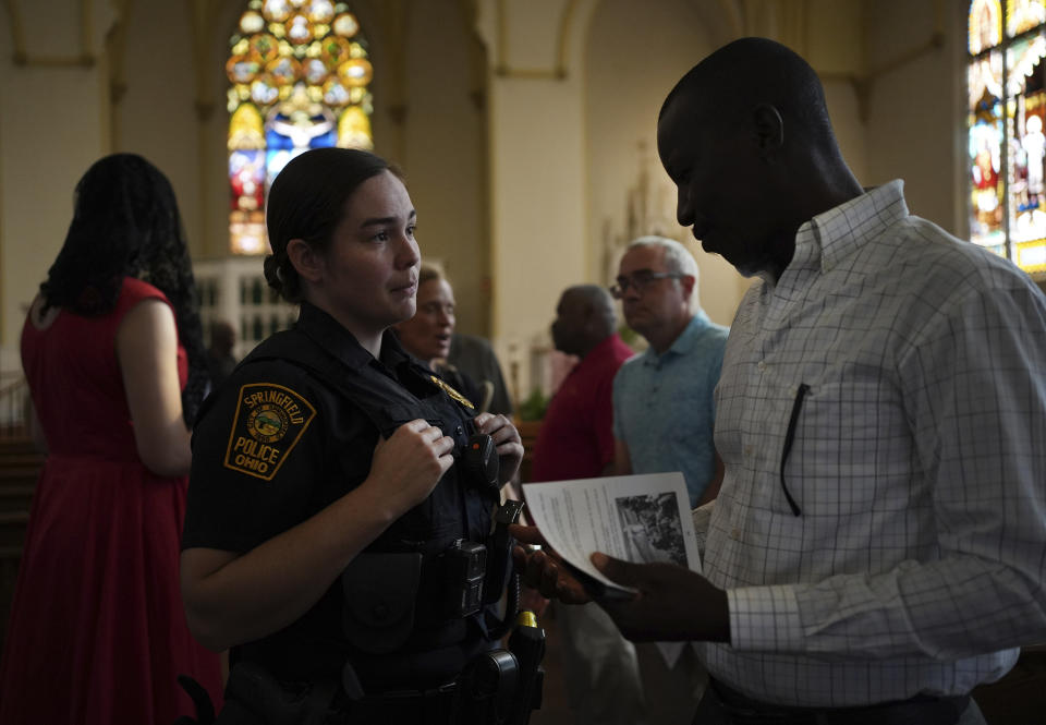 A Springfield police officer talks to a parishioner at St. Raphael Catholic church, Sept. 15. (Luis Andres Henao/AP)