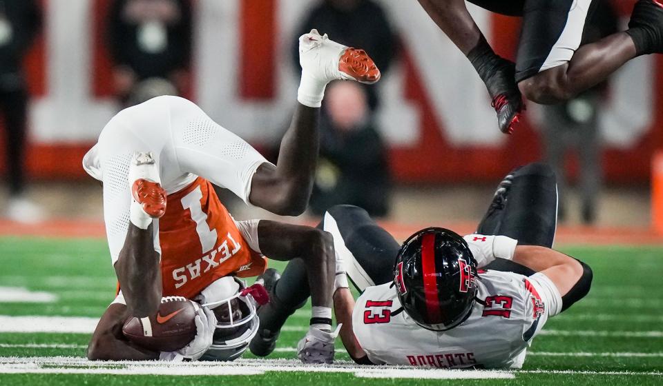 Texas wide receiver Xavier Worthy rolls after getting tackled by Texas Tech linebacker Ben Roberts in the third quarter. Worthy caught a touchdown during the game and tied for the team lead in receptions.