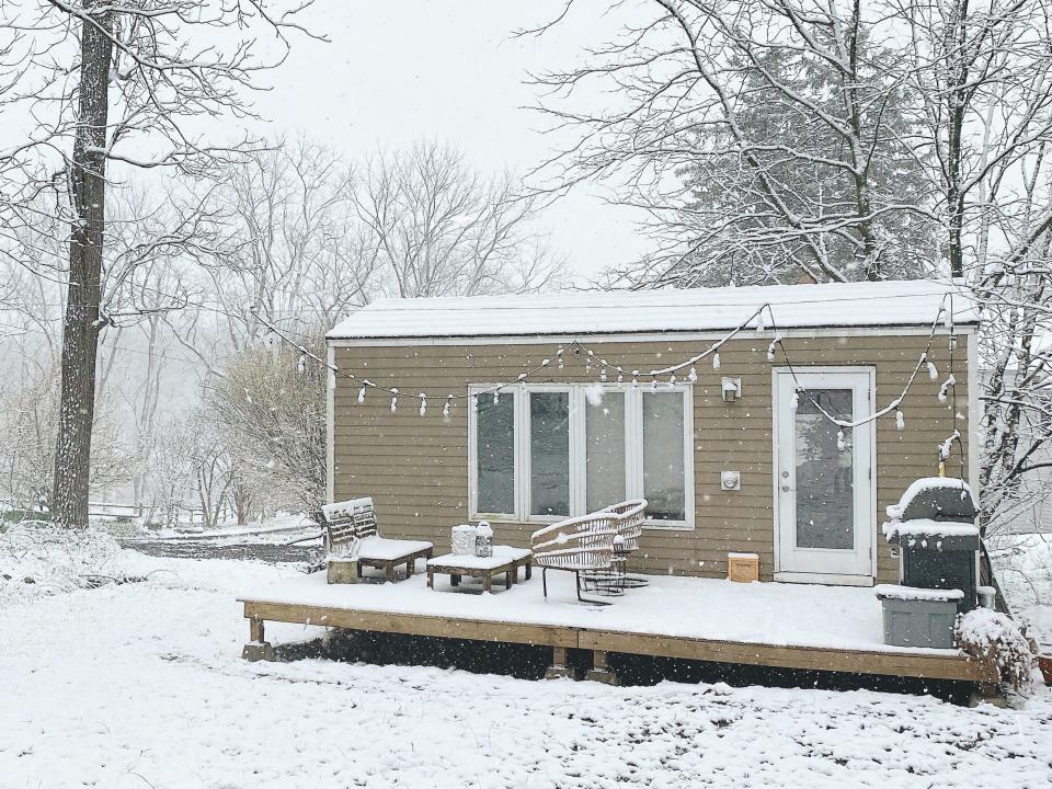 The exterior of Shannon Soine's tiny house during the winter with snow on the ground and deck