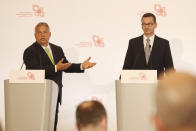 Hungarian Prime Minister Viktor Orban,left, speaks at a join news conference with Poland's Prime Minister Mateusz Morawiecki,right, following talks of government leaders of the Visegrad Group of regional cooperation that also includes the Czech Republic and Slovakia, in Warsaw, Poland, on Friday, July 3, 2020. Poland, which took the group's 12-month rotating presidency, is seeking a generous EU budget to help the region recover from the coronavirus pandemic.(AP Photo/Czarek Sokolowski)