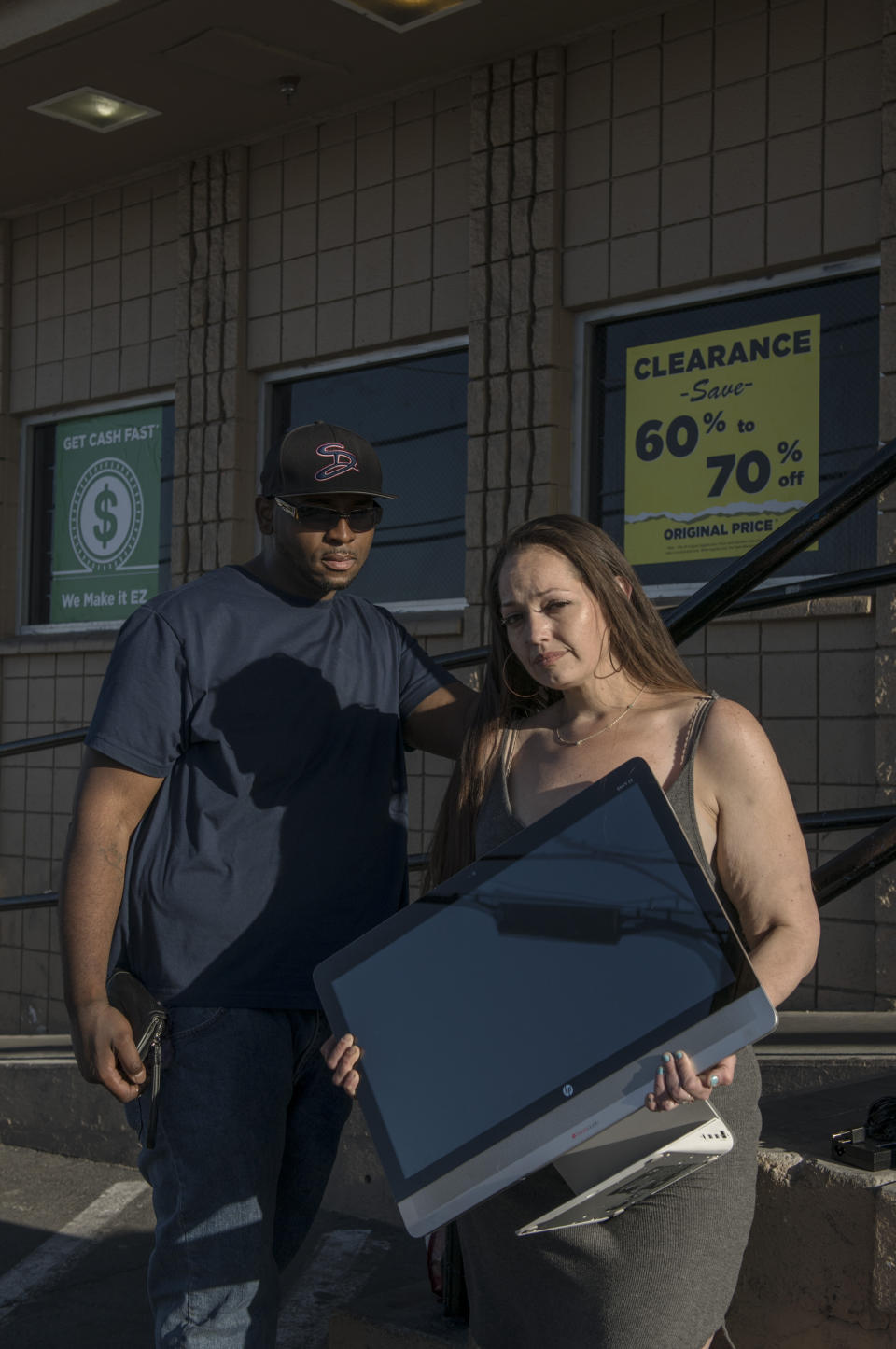 Cue and Sara Lovato wait in line with a computer they're hoping to sell at an EZPawn on April 13, 2020. &ldquo;Gotta get some gas,&rdquo; said Sara. Her work in behavioral health has been affected by the coronavirus. (Photo: BRIDGET BENNETT FOR HUFFPOST)