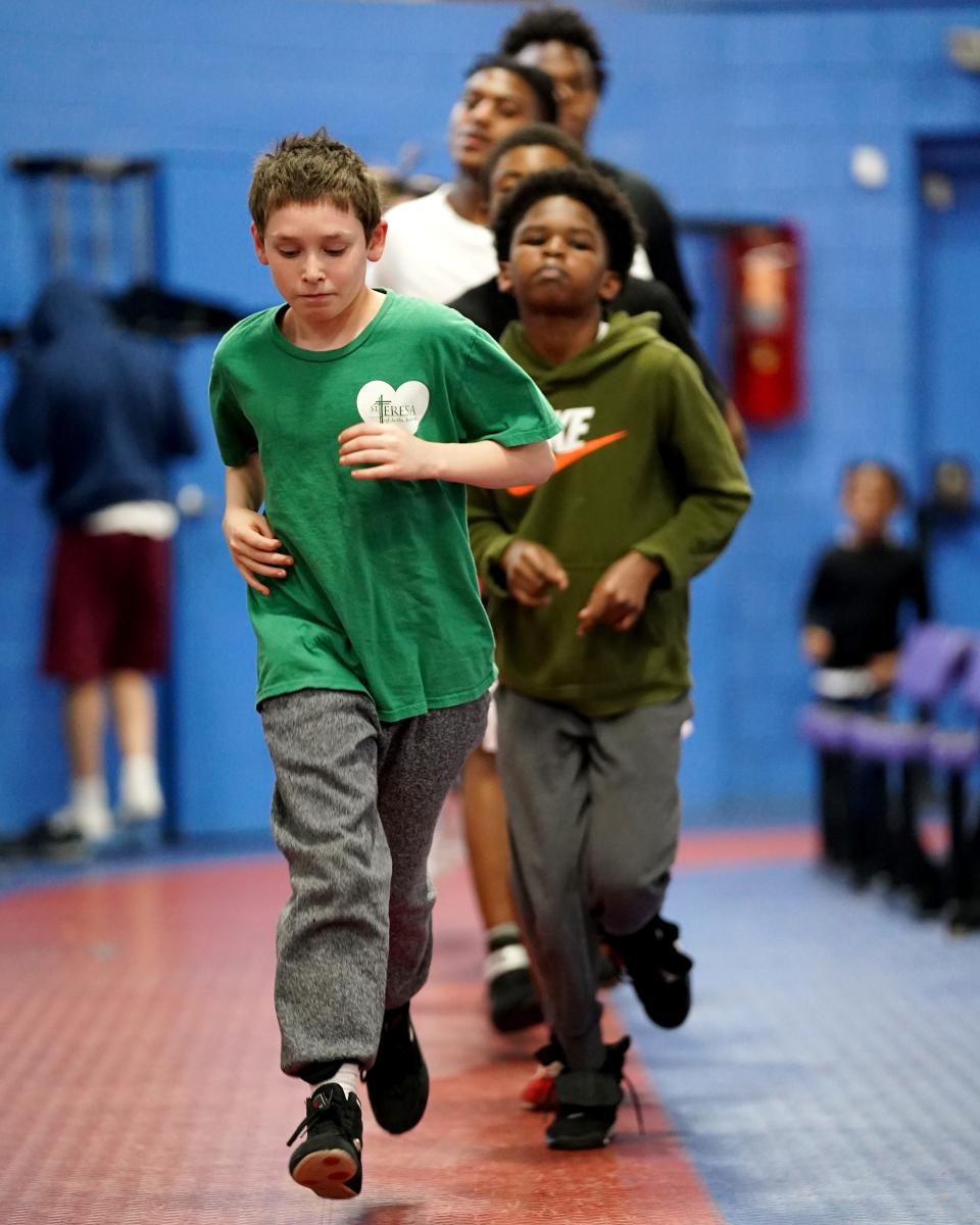 Kaleb Turner, Gique Hargrove, Gregory Collins and Michael Higgins run laps with other youth boxers, as they train at the Cincinnati Golden Gloves for Youth gym at the Over-the-Rhine Recreation Center.