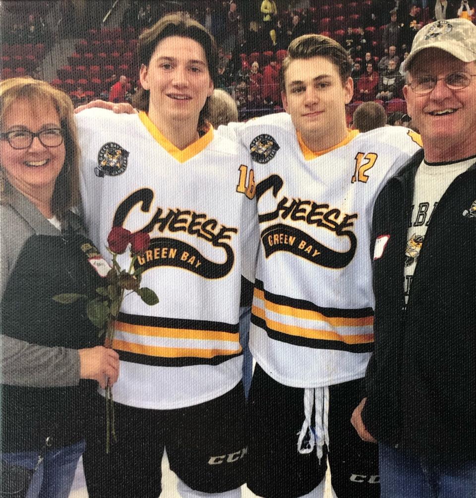 In this family photo, Tracy and Butch Ward of Ashwaubenon pose with Green Bay Gamblers players John Leonard and Chris Grando (12), who lived with the Wards while in junior hockey in 2015-16. Leonard went on to play in the NHL and is a member of the AHL's Milwaukee Admirals.