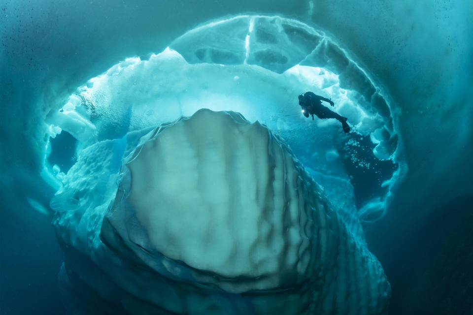 Stunning photos show dive beneath giant iceberg