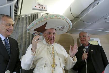 Pope Francis wears a Sombrero hat he received as a gift by a Mexican journalist aboard an airplane to Havana, February 12, 2016. REUTERS/Alessandro Di Meo/Pool