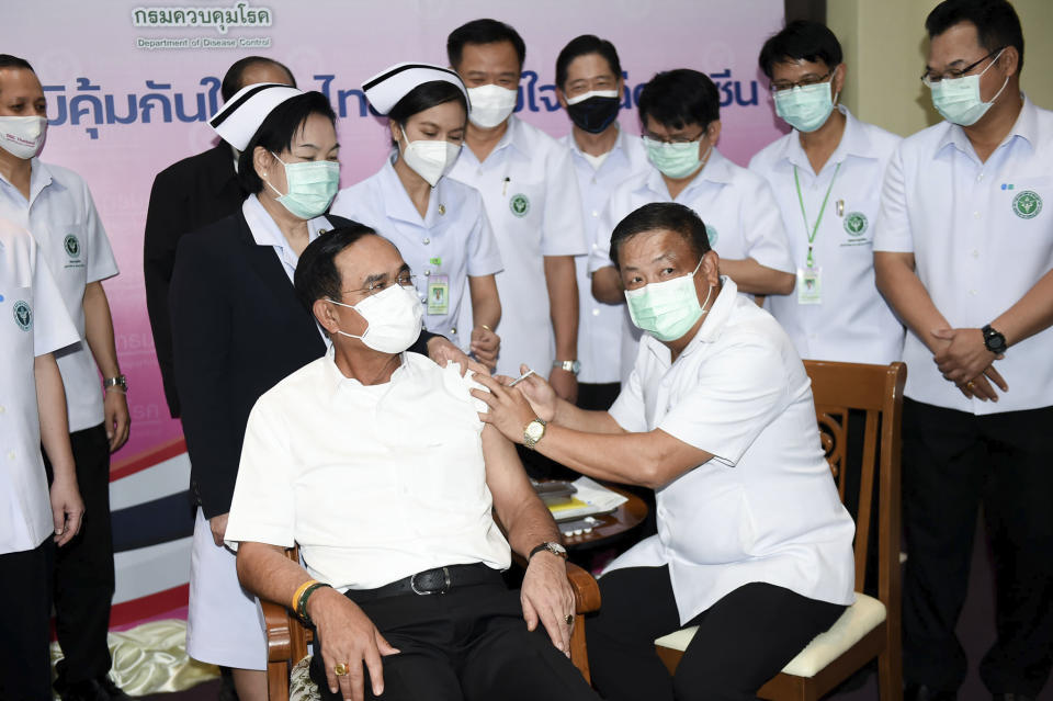 A health worker administers the second dose of the AstraZeneca COVID-19 vaccine to Thailand's Prime Minister Prayuth Chan-ocha, center left, at Bamrasnaradura Infectious Diseases Institute in Bangkok, Thailand, Monday, May 24, 2021. (Government Spokesman Office via AP)
