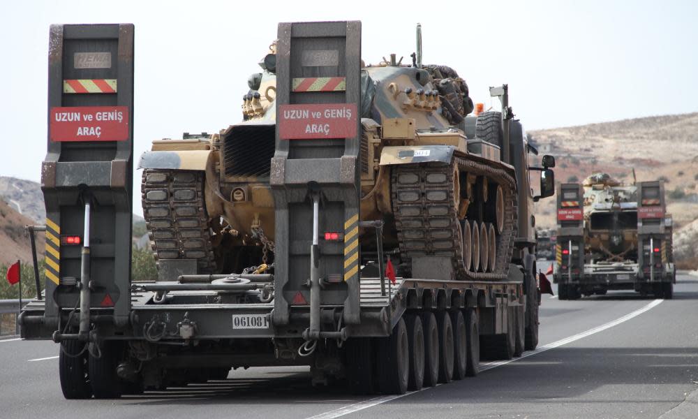 Turkish military trucks carry armoured vehicles towards the Syrian border near Gaziantep on Tuesday.