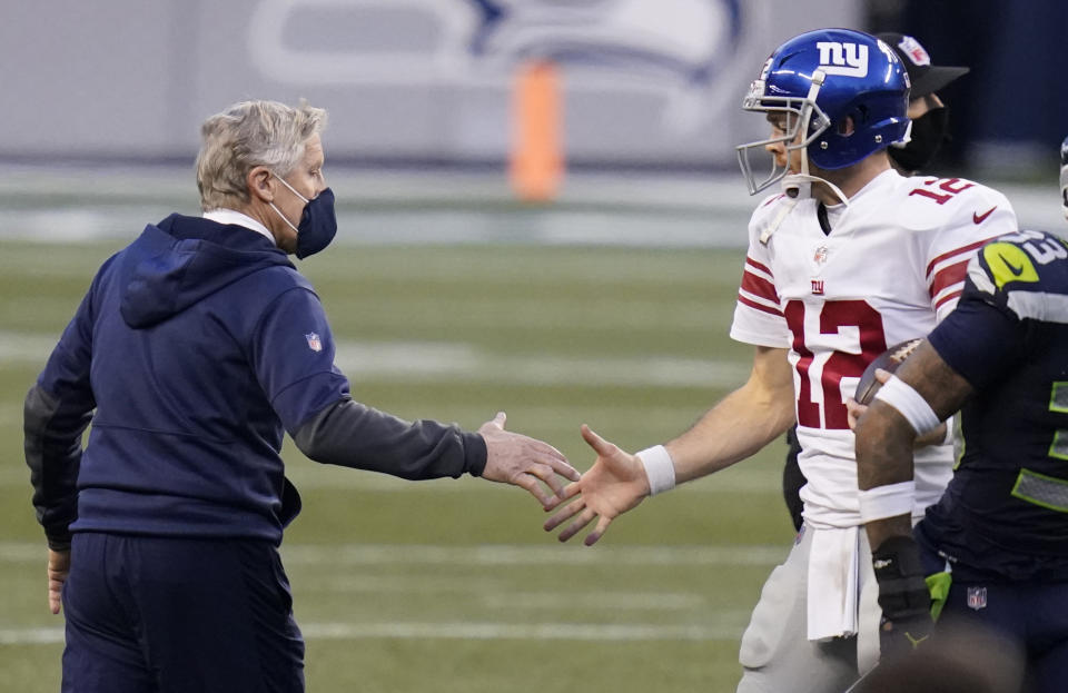 Seattle Seahawks head coach Pete Carroll, left, shakes hands with New York Giants quarterback Colt McCoy (12) after an NFL football game, Sunday, Dec. 6, 2020, in Seattle. The Giants won 17-12. (AP Photo/Elaine Thompson)