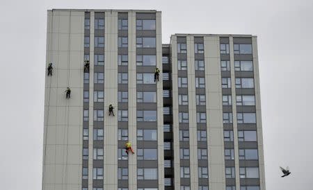 Specialists abseil down the side of Bray Tower to check the cladding, on the Chalcots Estate in north London, Britain, June 27, 2017. REUTERS/Hannah McKay