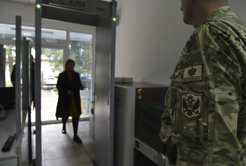 In this photo taken Monday, Nov. 11, 2019, a guard stands at the entrance of the Montenegrin Defense Ministry in Montenegro's capital Podgorica. Deployed inside the sprawling communist-era army command headquarters in Montenegro’s capital, a group of elite U.S. military cyber experts are plotting strategy in a fight against potential Russian and other cyberattacks ahead of the 2020 American and Montenegrin elections. (AP Photo/Risto Bozovic)