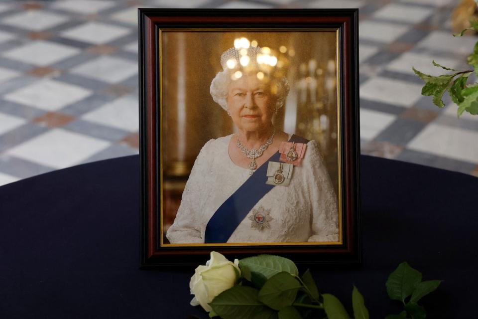 A white rose placed by French president Emmanuel Macron in front of a portrait of the Queen. (EPA)