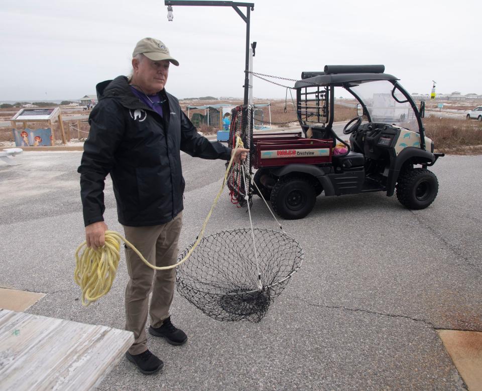 Navarre Beach Sea Turtle Conservation Center volunteer Bob Blais shows off some of the organization's turtle-saving gear on Friday, Dec. 30, 2022. 