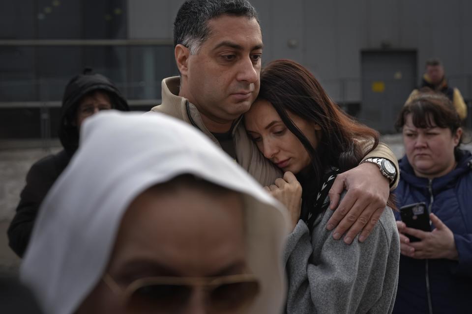 FILE - A couple stand at a makeshift memorial in front of the Crocus City Hall on the western outskirts of Moscow, Russia, on March 26, 2024. The attack on the concert hall, the bloodiest assault on Russian soil in two decades, appears to be setting the stage for an increasingly harsh response by President Vladimir Putin. Four suspects in the attack appeared in court showing signs of brutal treatment while in custody. (AP Photo/Alexander Zemlianichenko, File)