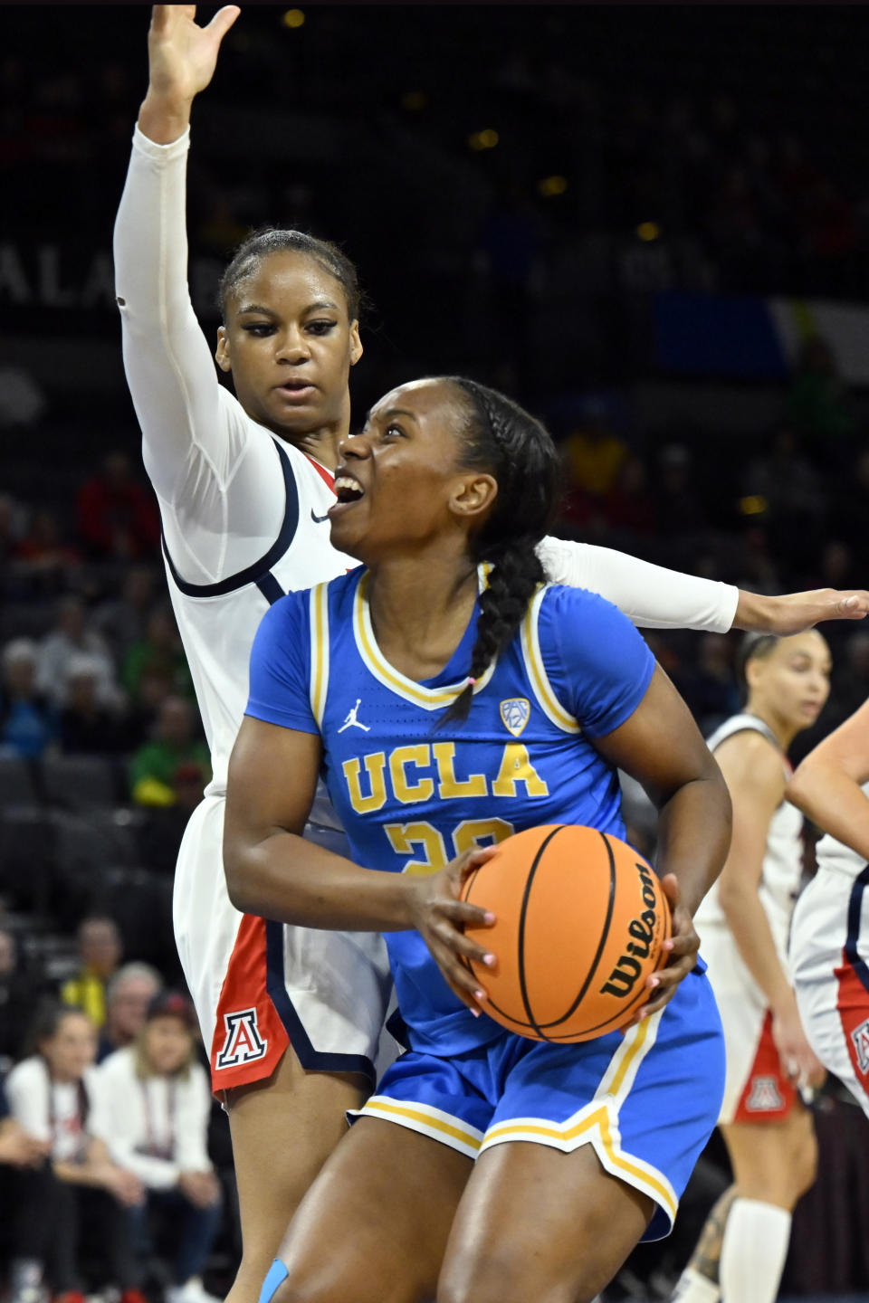 UCLA guard Charisma Osborne (20) looks to shoot against Arizona guard Lauren Fields, top, during the first half of an NCAA college basketball game in the quarterfinal round of the Pac-12 women's tournament Thursday, March 2, 2023, in Las Vegas. (AP Photo/David Becker)