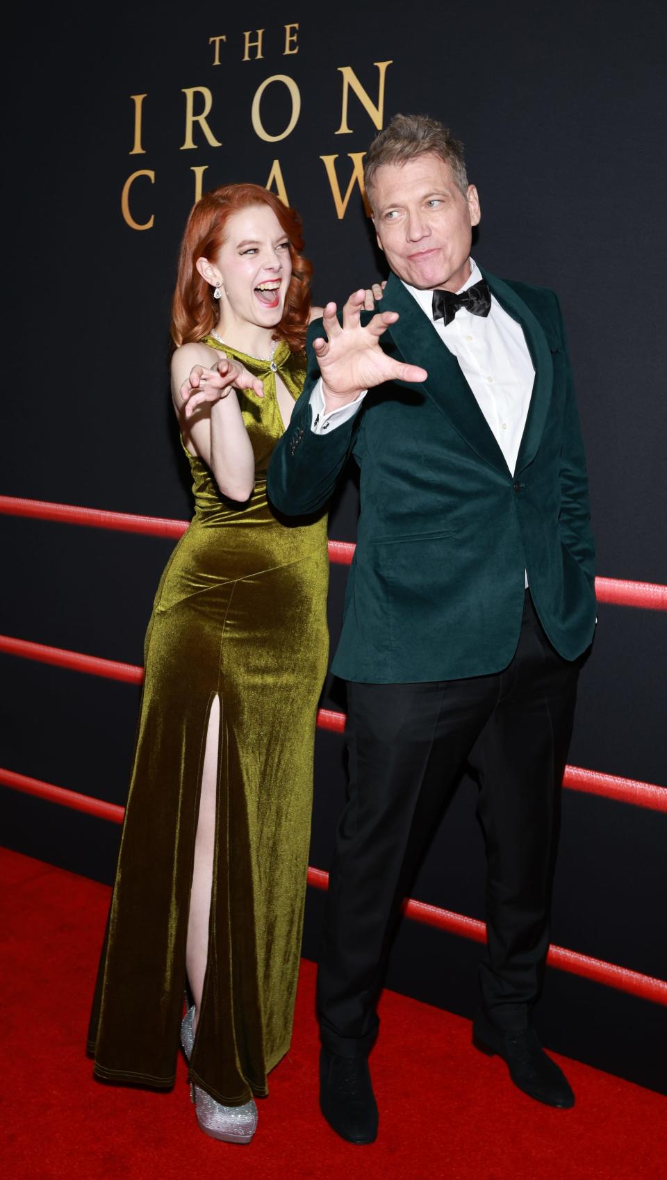 Desiree Bressend in green dress and Holt McCallany in turqouise suit at "The Iron Claw" premiere