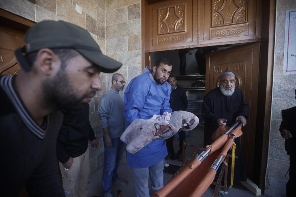 A morgue worked to bring out the body of a Palestinian child killed in the Israeli bombardment of the Gaza Strip in Khan Younis, Saturday, Jan. 6, 2023. (AP Photo/Mohammed Dahman)