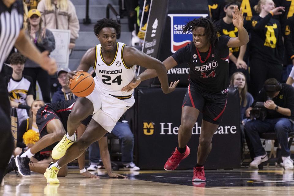 Missouri's Kobe Brown, left, dribbles around Southeast Missouri State's Nate Johnson, right, during the second half of an NCAA college basketball game Sunday, Dec. 4, 2022, in Columbia, Mo. (AP Photo/L.G. Patterson)