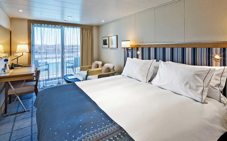 <p>All 464 staterooms come with balconies—a huge perk for when you’re sailing in warmer climes. In terms of total size, the rooms range from a 270 square-foot veranda cabin on up to a 757+ square-foot Explorer’s Suite, which comes with a separate living room, wraparound balcony, and deep soaking tub. All of the cabins are bright, airy, and done in a crisp blue and white palette, with cheerful striped fabric headboards, navy leather-covered coffee tables, and chic wool blankets with a traditional Marius weave. Other touches include blonde wood desks and closets, and ceramic stone bathrooms with Freyja bath amenities. </p>