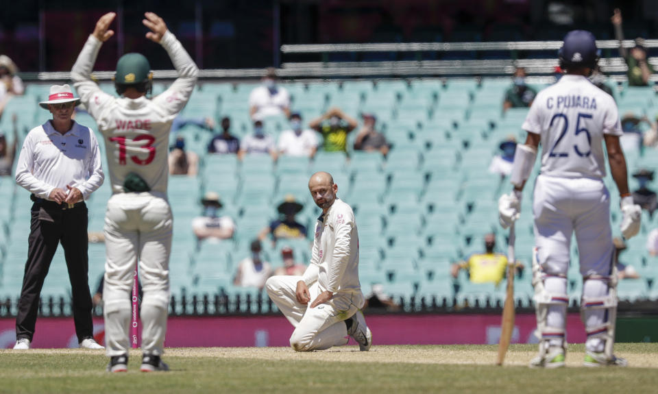 Australia's Nathan Lyon reacts after an appeal for LBW against India's Cheteshwar Pujara, right, is rejected during play on the final day of the third cricket test between India and Australia at the Sydney Cricket Ground, Sydney, Australia, Monday, Jan. 11, 2021. (AP Photo/Rick Rycroft)