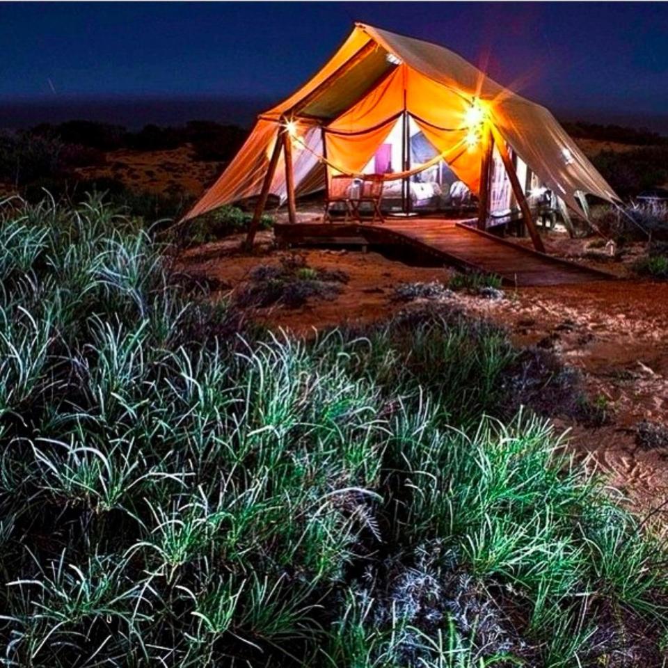 The tent is decked out with a wraparound deck, a hammock and four-poster bed.