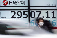 A man wearing a protective mask stands in front of an electronic stock board showing Japan's Nikkei 225 index at a securities firm Friday, Feb. 26, 2021, in Tokyo. Asian shares skidded Friday after rising bond yields triggered a broad sell-off on Wall Street that erased the markets gain for the week and handed the Nasdaq composite index its steepest loss since October. (AP Photo/Eugene Hoshiko)