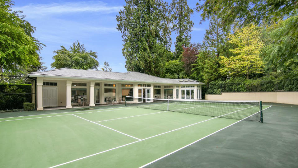 Private tennis court surrounded by trees