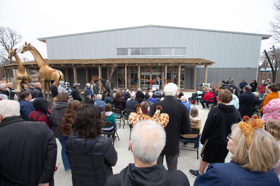 Community members gather around the new Giraffe & Friends exhibit at the Topeka Zoo.