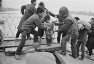 <p>Vietnamese refugees crossing the wrecked Trường Tiền Bridge over the Perfume River during the Battle of Huế, Vietnam War, February 1968. (Photo: Terry Fincher/Daily Express/Hulton Archive/Getty Images) </p>