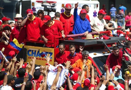 Venezuelan President Hugo Chavez (C) waves to supporters during a campaign rally in Sabaneta, Barinas state. Chavez sang, greeted throngs of supporters and lodged a searing attack on his rival Monday as he stormed into the final stretch of his re-election campaign