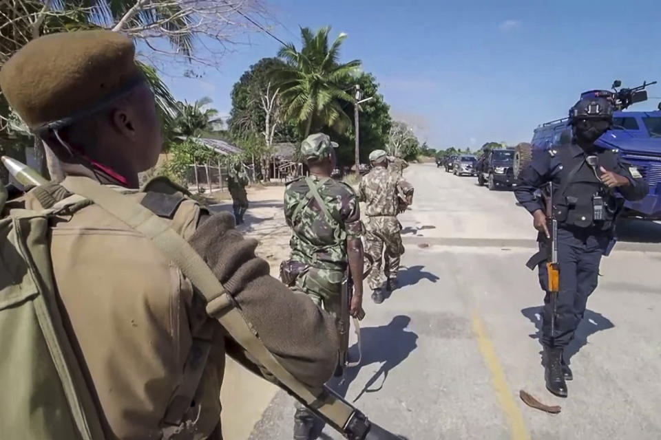 FILE - In this image made from video, a Rwandan policeman, right, and Mozambican military, left, patrol near the Amarula Palma hotel in Palma, Cabo Delgado province, Mozambique Sunday, Aug. 15, 2021. Fleeing beheadings, shootings, rapes and kidnappings, nearly 1 million people are displaced by the Islamic extremist insurgency in northern Mozambique. (AP Photo/Marc Hoogsteyns, File)