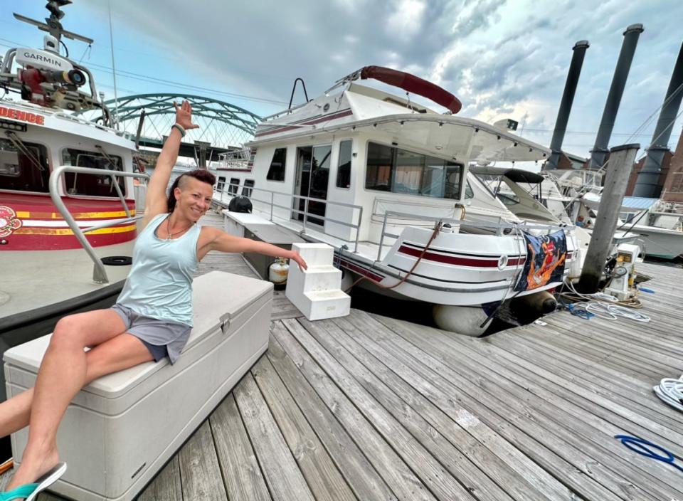 Stacy Rae Seminick with her Gibson Twin Crusader houseboat, her one and only home, docked at the Providence Marina near the Hot Club.