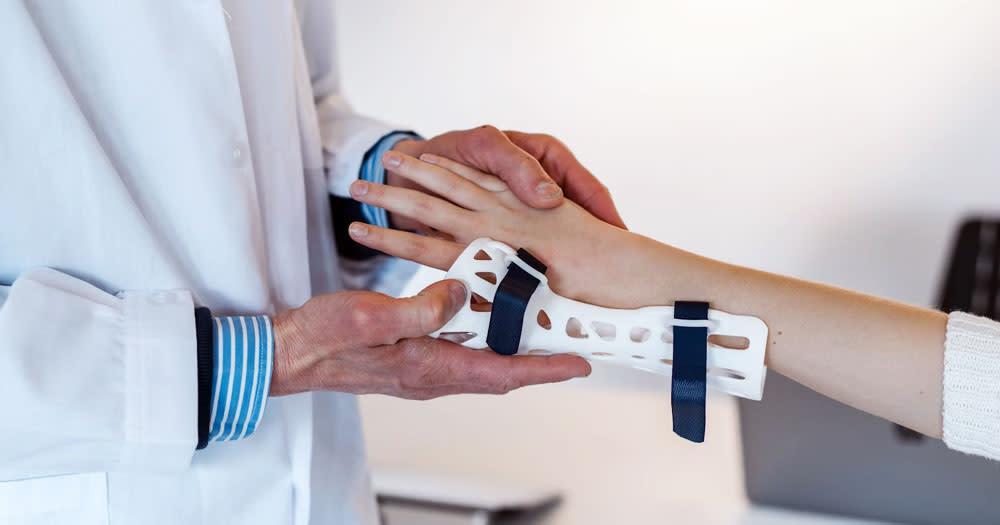 A new study finds Irish healthcare professionals have a positive attitude towards LGBTQ+ young people. The photo shows the hands of a doctor treating a teenager with a sprained wrist.