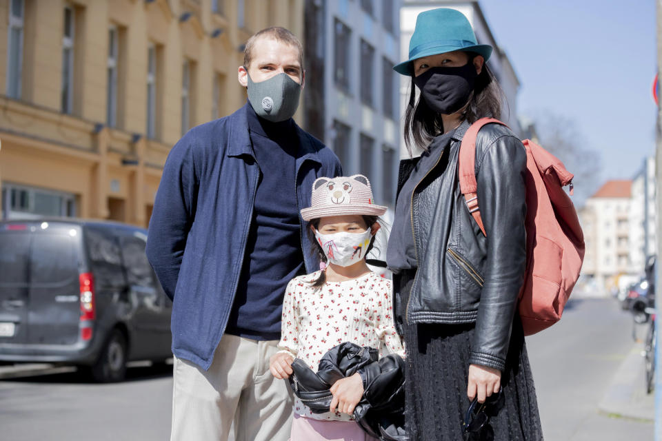 06 April 2020, Berlin: Vinzenz Wagner (l-r), the 7-year-old Mika and Lih Wong stand together in Berlin-Mitte with protective masks for a photo. In order to slow down the spread of the corona virus, the German government has considerably restricted public life. Photo: Christoph Soeder/dpa (Photo by Christoph Soeder/picture alliance via Getty Images)